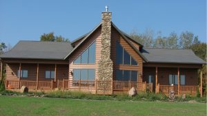 Log-style home with vaulted roof and custom windows